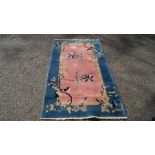 A Chinese rug, with allover vine leaf and grape design on a soft salmon pink ground,