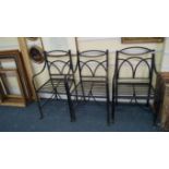 A pair of Regency black painted wrought iron garden armchairs;