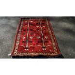 A Southern Persian Qashgai rug, with stylised trees and geometric motifs on a red field,