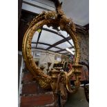 A gilt framed circular wall mirror, with three candle sconces, 53cm wide.