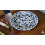 A Chinese blue and white dish, Xuande six character mark, painted with a peacock in a landscape,