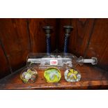 A novelty glass ship in a bottle; together with a pair of pewter and glass candlesticks;