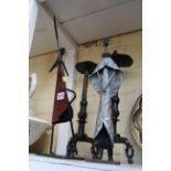 A pair of Eastern patinated metal tripod candlesticks,