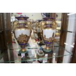 A pair of Continental porcelain twin handled vases, in the Empire style, on slate bases,