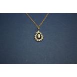 A 14ct synthetic sapphire and white sapphire set tear drop pendant on 14ct gold necklace.