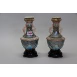 An unusual pair of twin handled shell vases, each on a lacquered stand, total height 24cm.