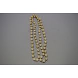 A Chinese ivory bead necklace, of seventy-one graduated oval beads,