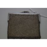 An Oriental silver mesh purse, stamped '85', with silk lining.