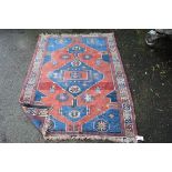 A Caucasian Kazati rug, with large central blue medallion on a red field, 148 x 120cm.