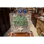 An old painted wrought iron firescreen.