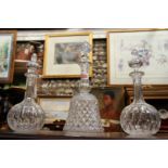 A pair of decanters and stoppers; together with another decanter and stopper.