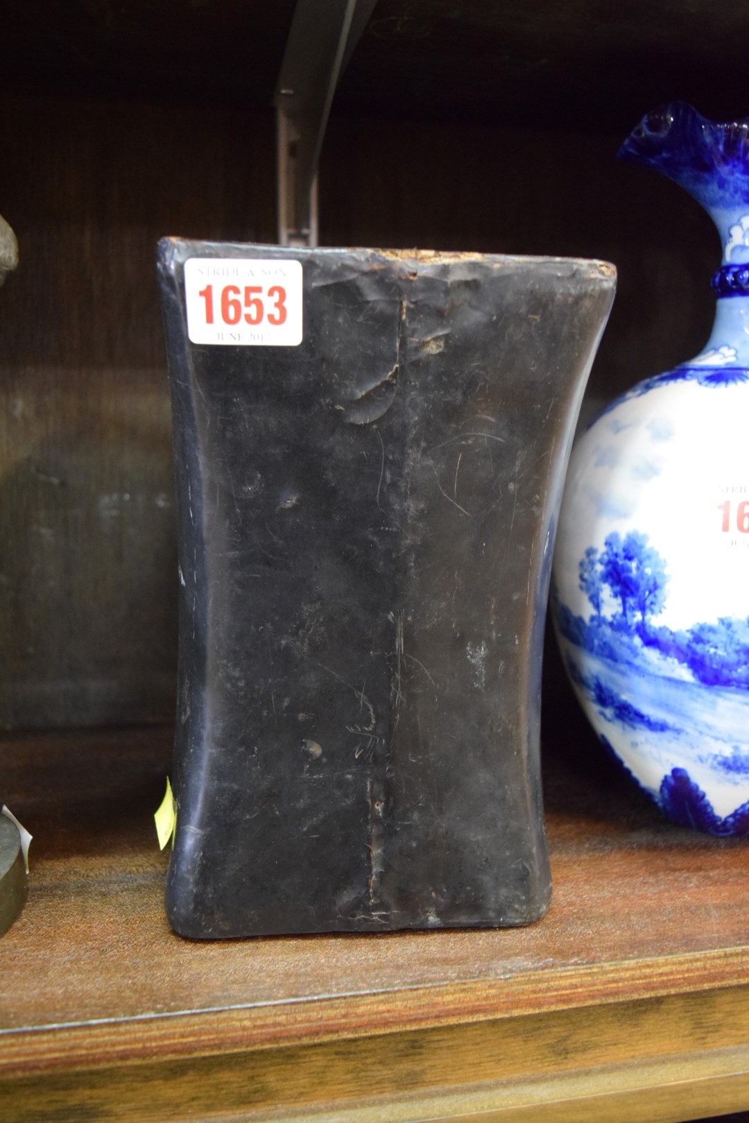 A Chinese black lacquered headrest or pillow, 21cm wide.