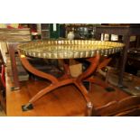 An Indian brass oval tray, with scalloped edge, 85.5cm wide, on folding wood stand.