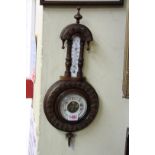 A carved walnut framed aneroid barometer.