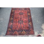 A fine Afghan rug, having two central medallions on a floral red field, 150 x 103cm.