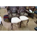 A set of four Victorian carved walnut balloon back salon chairs