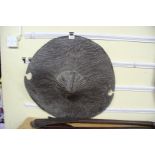 African: a Sudan circular hide shield, having a central boss and cut outs to the rim,