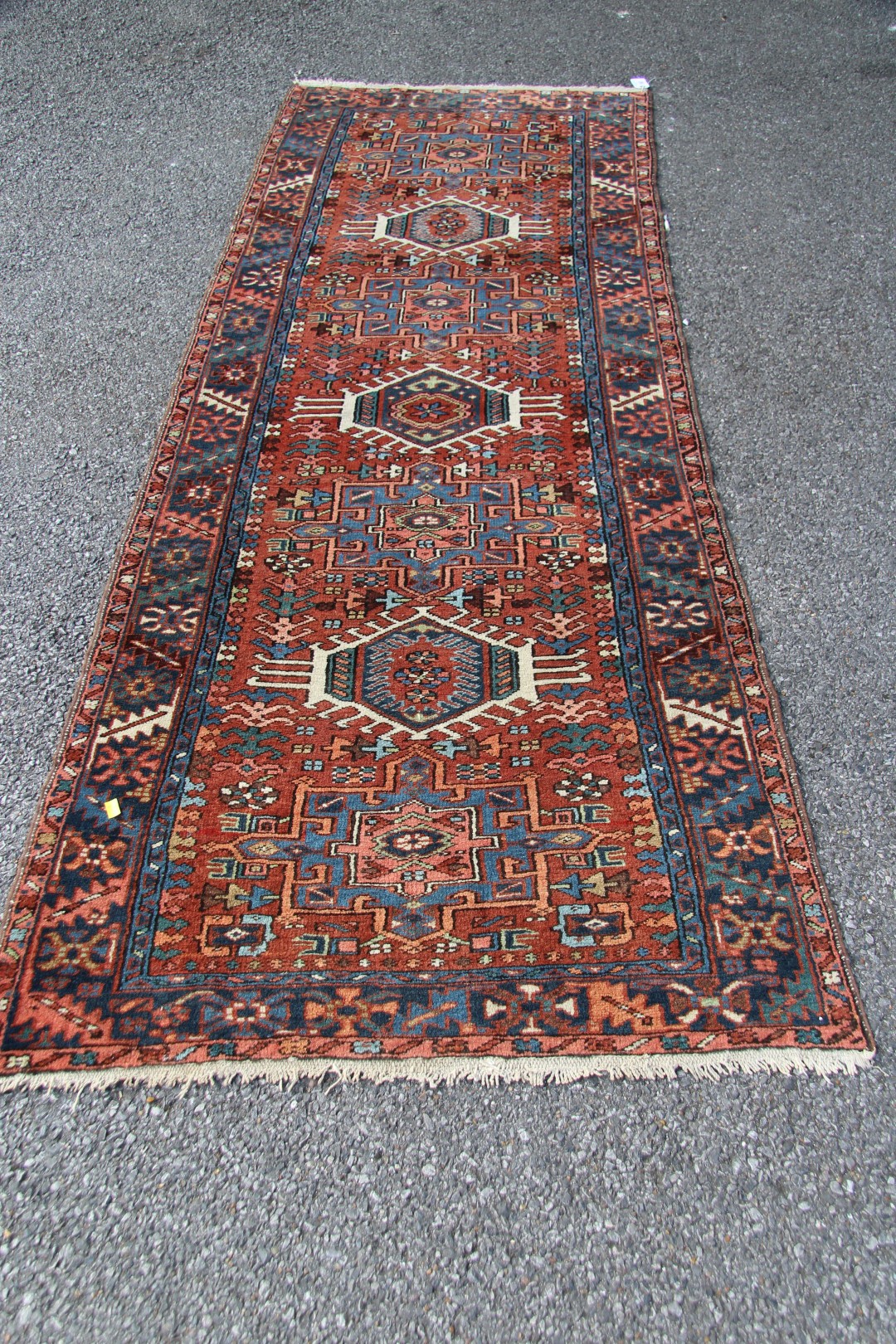 A North West Persian Karaja runner, with seven medallions on a geometric design red field,
