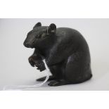 A Japanese bronze rat, Meiji period, realistically modelled and chased, holding a nut in its paws,