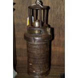 An old steel miner's lamp, indistinctly inscribed to the base 'Mine Supply Company, Barnsley',
