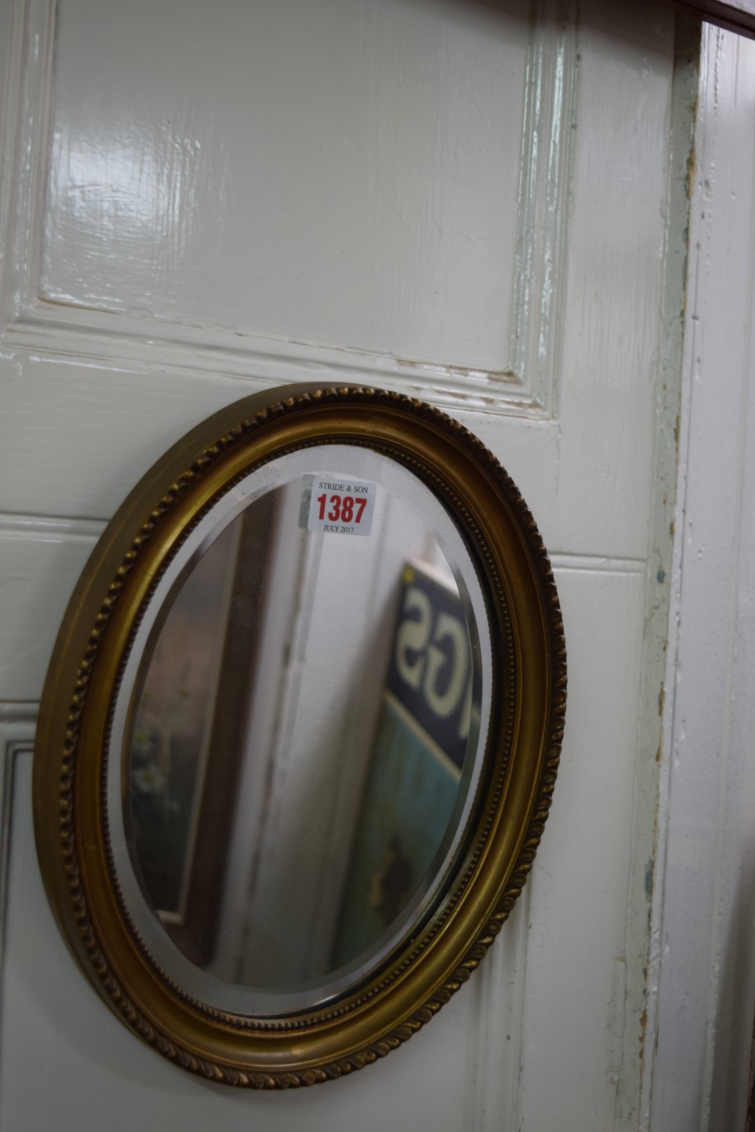 A small giltwood framed oval wall mirror, 29 x 24cm.