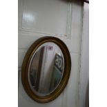 A small giltwood framed oval wall mirror, 29 x 24cm.