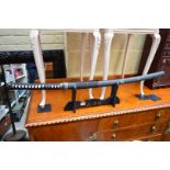 A reproduction Japanese Katana and scabbard, on wooden stand.