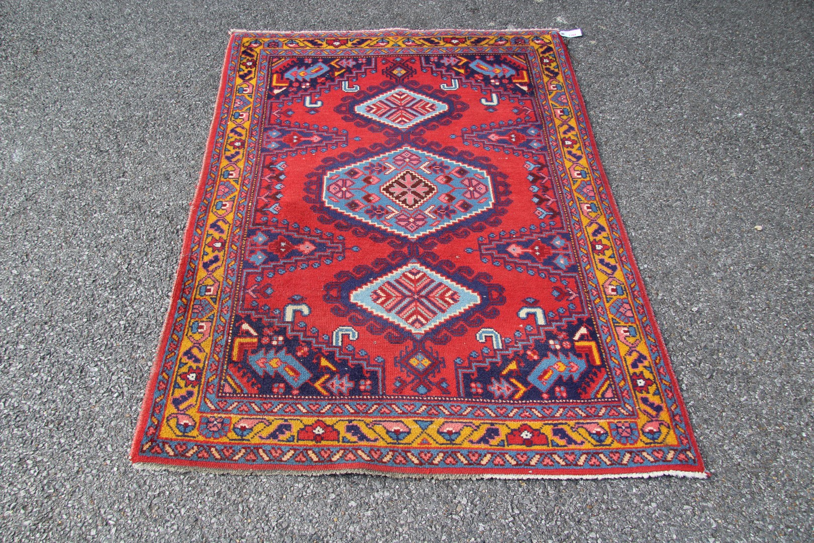 A North West Persian triple medallion rug on a red field, 151 x 105cm.