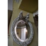 A Sitzendorf blanc de chine oval wall mirror, with cherub surmount, 33cm high.