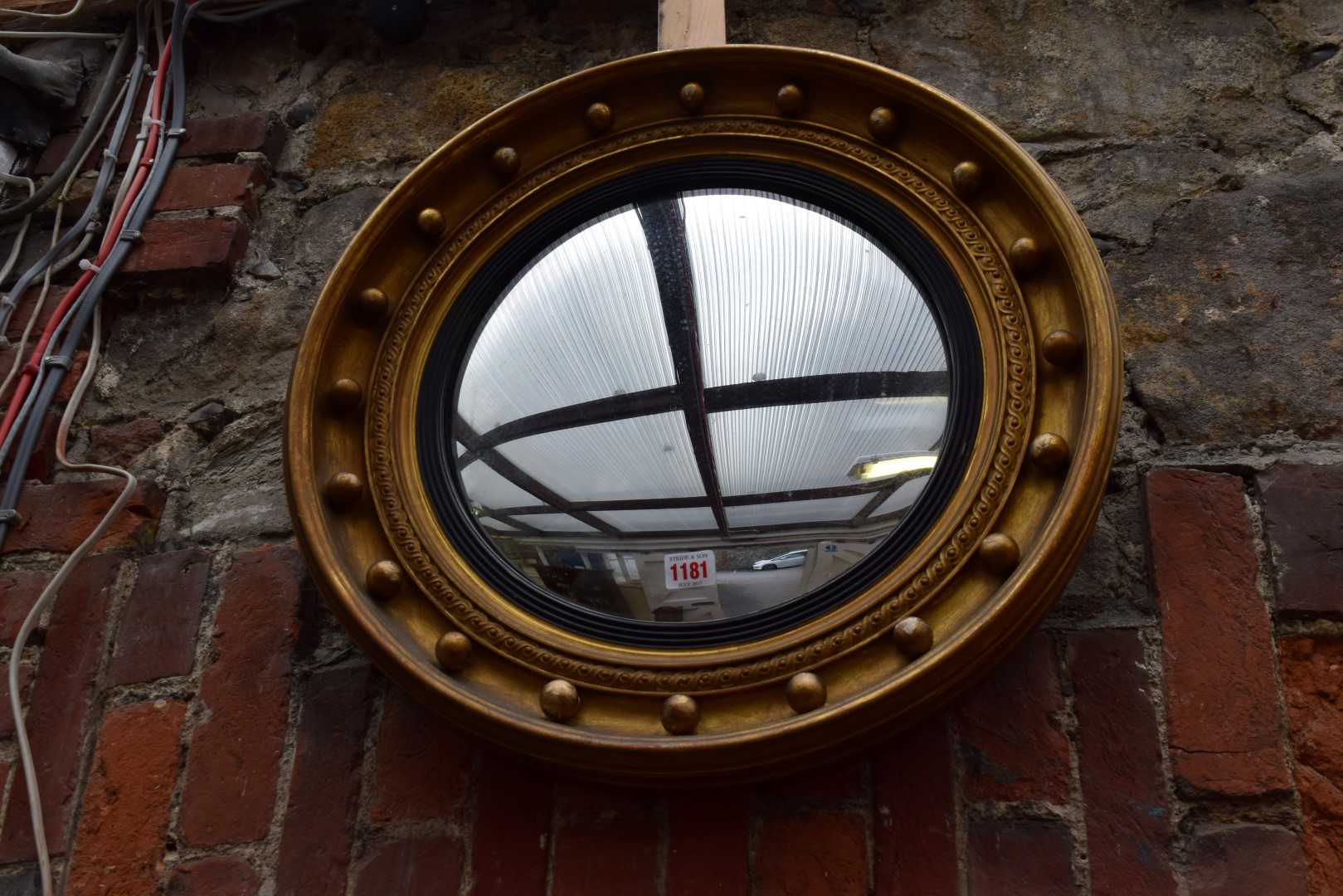 An old gilt wood framed circular convex wall mirror, 55cm diameter.