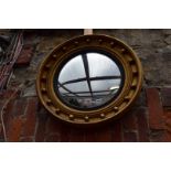 An old gilt wood framed circular convex wall mirror, 55cm diameter.