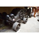 A pair of 19th century cast iron cannon carriages, each with four wheels and dolphin decoration.