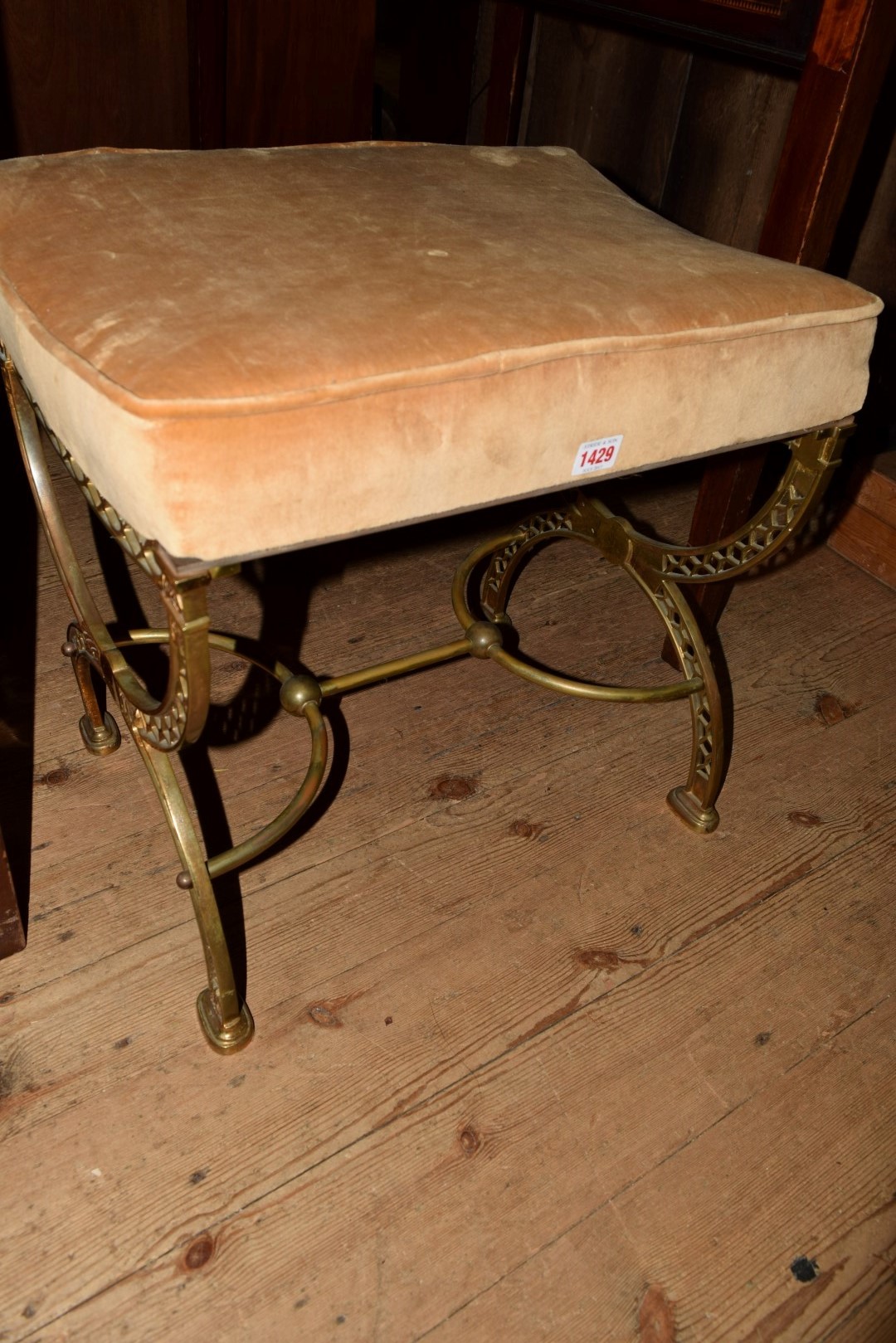 A cast and pierced brass X frame stool.