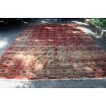 A large Turkoman carpet, with 6 x 13 Gul design on an abrashed red field, 374 x 283cm.