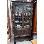 An early 20th century carved oak and leaded glass bookcase, labelled 'Merryweather & Son, Holloway,