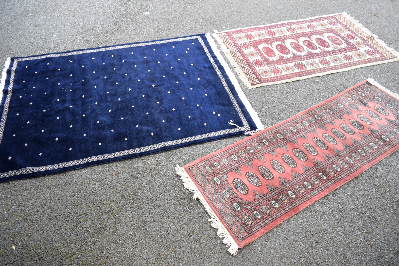 An Afghan rug; together with a blue field Pakistan rug and a narrow Pakistan runner.