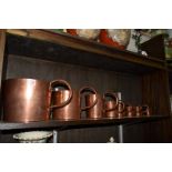 A graduated set of eight copper naval rum measures, 1 gallon to 1/2 gill.