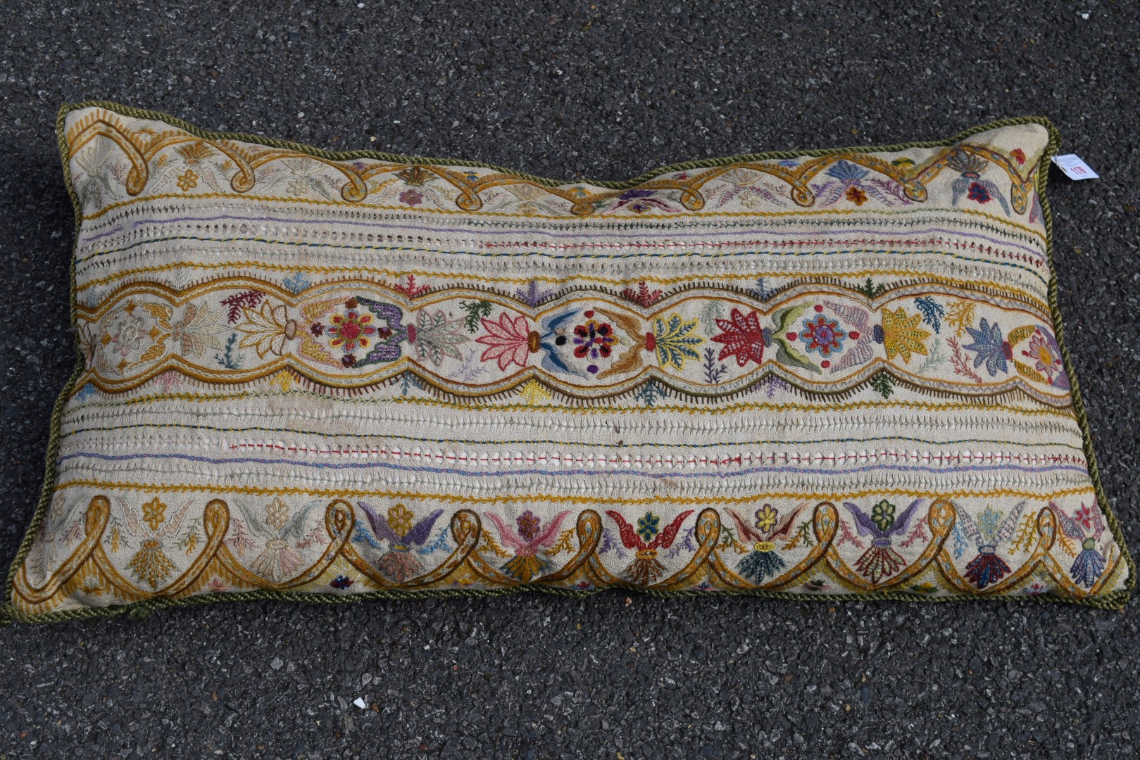 A crewel work cushion with stylised needlework decoration, 92 x 49cm.