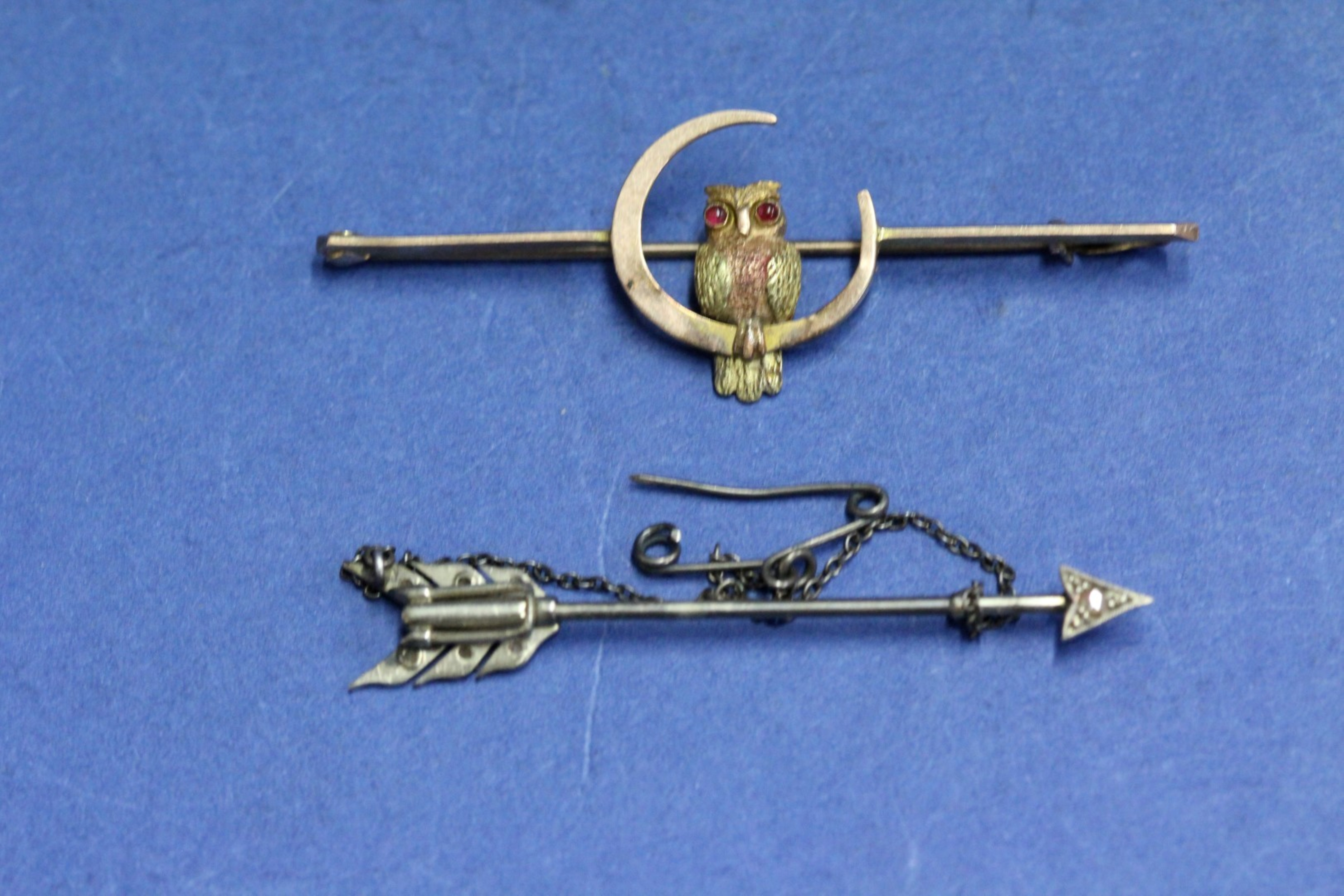 A 9ct gold owl and moon bar brooch, 2.9g; together with an unmarked arrow pin, 7.9g.