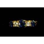 An 18ct gold ring set three sapphires and two diamonds.