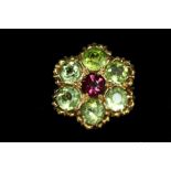 An unmarked yellow metal ring set central garnet surrounded peridots.
