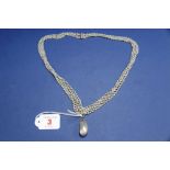 A large Baroque pearl in a mine cut diamond set mount on an associated four strand freshwater pearl