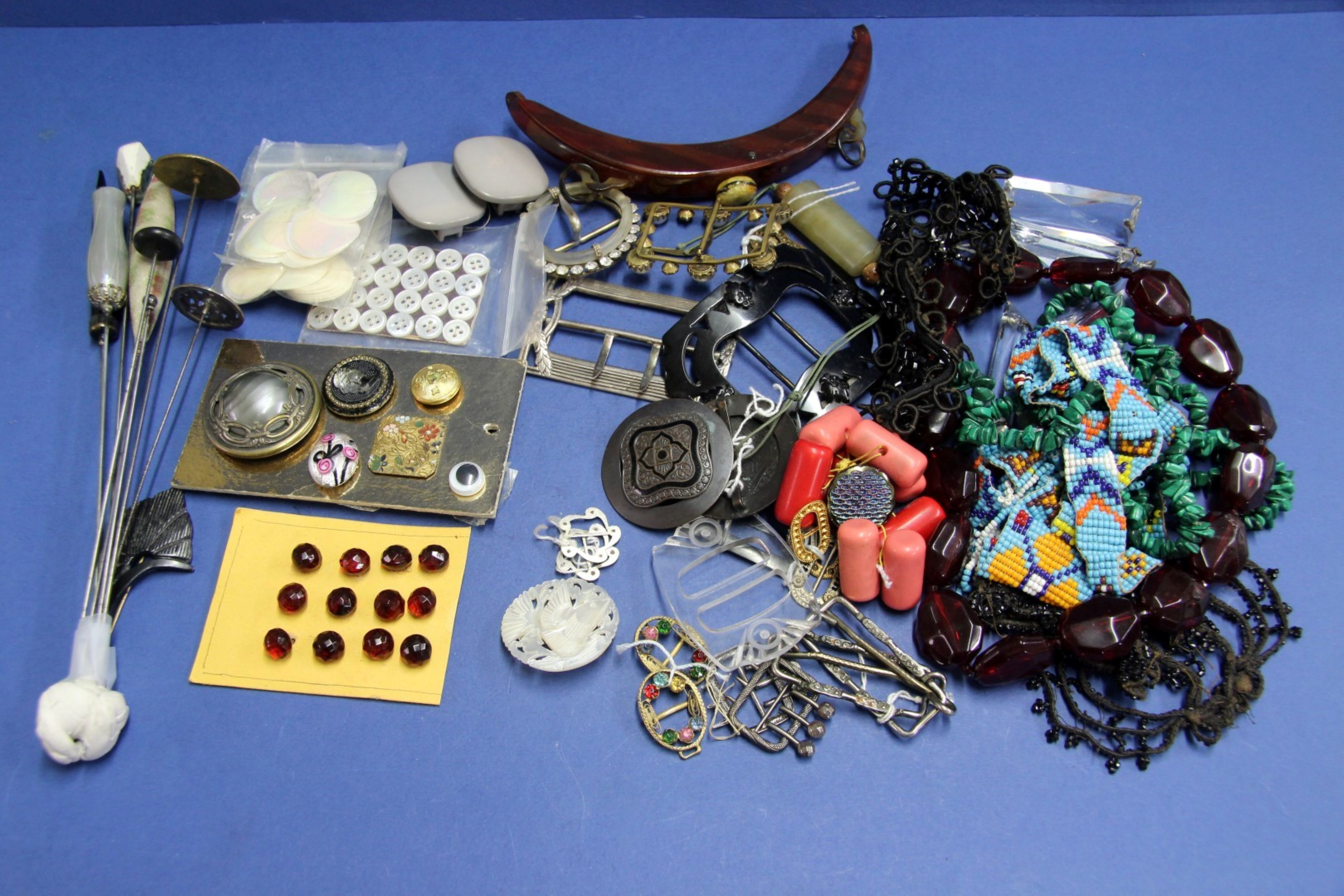 A collection of hat pins, buckles, and buttons.