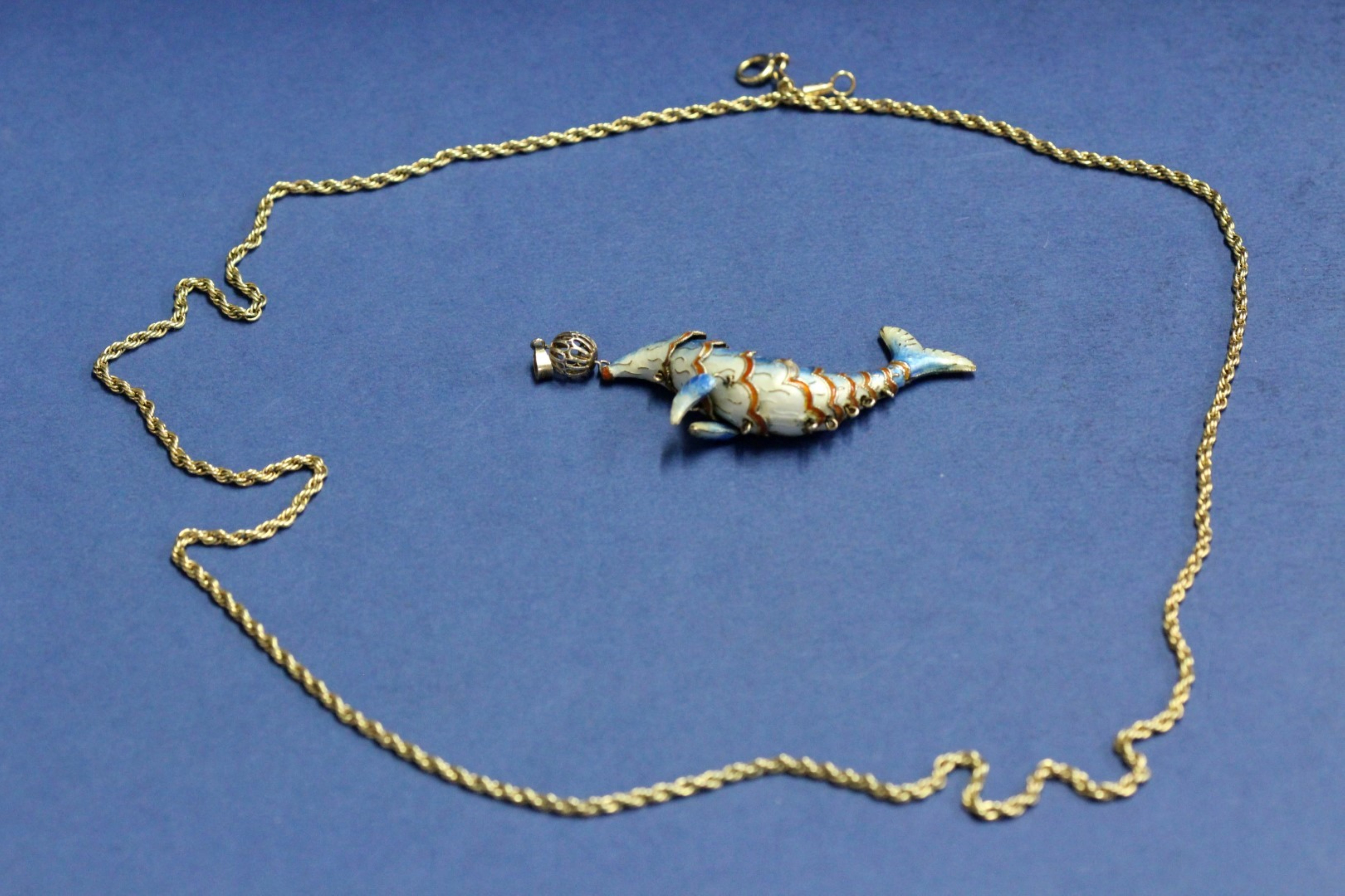 A silver and enamel articulated seal pendant; together with a 14k gold rope twist necklace, 13.7g.