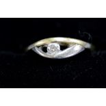 An unmarked yellow and white metal ring set single diamond.