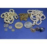 A small bag of pearl necklaces and silver rings.