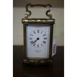 An old brass carriage timepiece, of serpentine outline, height including handle 15.