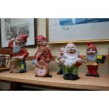 Six old polychrome painted pottery gnomes, largest 26.5cm high.