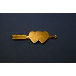 A yellow metal arrow and heart tie clip, 4.6cm wide, 3.9g.