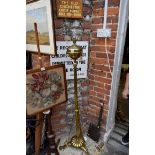 A Victorian brass standard oil lamp, with tripod base and adjustable column.